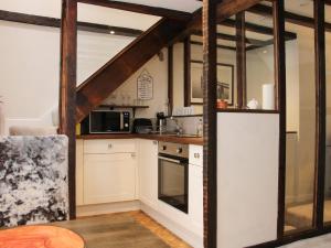 a kitchen with white cabinets and a stove top oven at Hazel Cottage in Bridgnorth