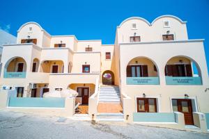 a large white building with arched windows and stairs at Antonia Apartments in Fira