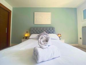 1 dormitorio con 1 cama con toallas en The Hayes - LONG STAY OFFER - Central Cardiff Abode by CTO Serviced Apartments, en Cardiff