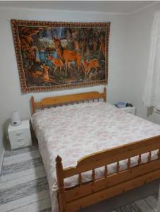 1 dormitorio con 1 cama con una pintura en la pared en Pajala, talo aavan reunalla, en Nivala