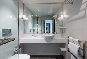 a bathroom with a sink, toilet, and bathtub at Fable Christchurch in Christchurch
