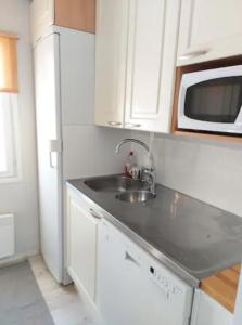 a kitchen with a sink and a microwave at Pajala, talo aavan reunalla in Nivala