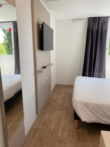 A bed or beds in a room at Kyriad Direct - Bourg les Valence