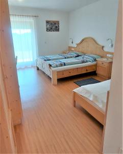 1 Schlafzimmer mit 2 Betten und Holzboden in der Unterkunft B&B Gasthaus Lieg in Kastelruth