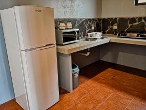 a kitchen with a refrigerator and a microwave at Sunset Vista Lodge,Monteverde,Costa Rica. in Monteverde Costa Rica