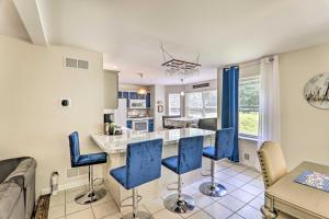 a kitchen and living room with blue chairs and a counter at Poconos Farms Escape with Fire Pit and Private Hot Tub in Tobyhanna