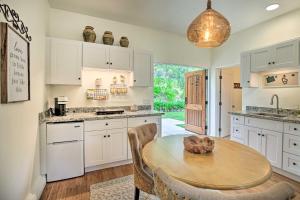 a kitchen with white cabinets and a wooden table at Rancho Santa Fe Casita - Gate Guarded Community! in Rancho Santa Fe