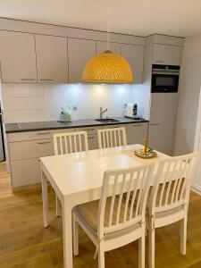 a kitchen with a white dining table and chairs at Studio de luxe, au coeur de la vieille ville in Sion