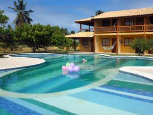 a swimming pool with balloons in a resort at Pousada Anga in Baixio