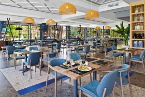 a restaurant with wooden tables and blue chairs at Hotel Riu Tikida Garden - All Inclusive Adults Only in Marrakech