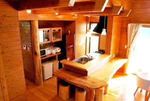 - une cuisine avec un évier dans une cabane en bois dans l'établissement Karin Design Cottage, à Onna
