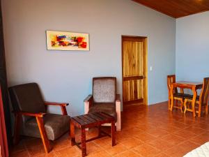 salon z krzesłami, stołem i krzesłem w obiekcie Sunset Vista Lodge,Monteverde,Costa Rica. w mieście Monteverde