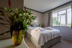 ein Schlafzimmer mit einem Bett und einer Vase aus Blumen in der Unterkunft Tudhoe Park House in Durham