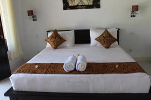 a bedroom with a bed with two towels on it at Magus Homestay in Pemuteran