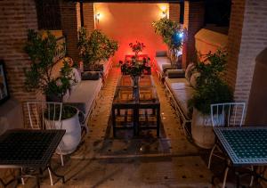 uma sala com sofás e mesas e vasos de plantas em Riad Romance em Marrakech