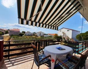 eine Terrasse mit einem Tisch und Stühlen auf dem Balkon in der Unterkunft Apartment Gloria in Zadar