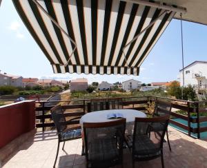 patio ze stołem i krzesłami na balkonie w obiekcie Apartment Gloria w mieście Zadar