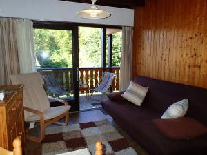 a living room with a couch and chairs on a deck at Les Gets apartment in Les Gets