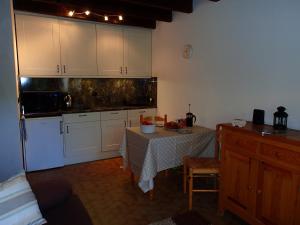 a kitchen with a table and white cabinets at Les Gets apartment in Les Gets