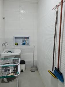 Un baño blanco con lavabo e inodoro. en Casa nova, conforto total e perto da praia, en Peruíbe 17 fotos más