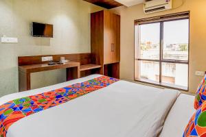 um quarto com uma cama com um cobertor colorido em FabHotel Eros 211 em Calcutá