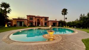 a large swimming pool in front of a house at Villa Minzah By La Siredrah in Marrakesh
