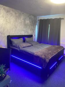 Un dormitorio con una cama con luces azules. en Hotel Boxberg, en Waldbröl