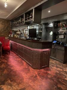 a bar in a restaurant with a red chair at Hotel Boxberg in Waldbröl