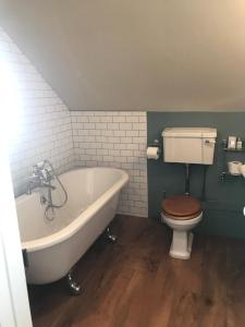 a bathroom with a bath tub and a toilet at Duke of Monmouth penthouse luxury apartment, Lyme Regis, 3 bedroom, Hot tub, Garden, dog friendly in Lyme Regis