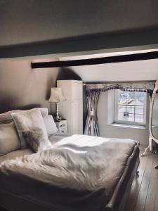 1 dormitorio con cama y ventana en Duke of Monmouth penthouse luxury apartment, Lyme Regis, 3 bedroom, Hot tub, Garden, dog friendly, en Lyme Regis
