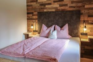 a bedroom with a bed with pink sheets and pillows at Apartment Steger 2 in Mittersill