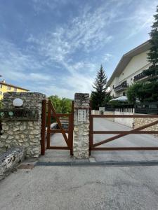 drewniana brama z kamienną ścianą i płotem w obiekcie Appartamento Fiore Rocca w mieście Rocca di Mezzo