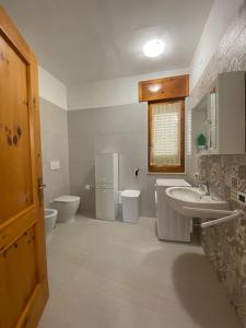 ein Badezimmer mit zwei WCs, einem Waschbecken und zwei Waschbecken in der Unterkunft Villa Vistasalentina BIS Appartamento Delux in Torre Colimena