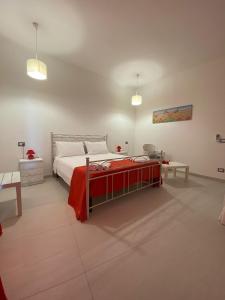 ein Schlafzimmer mit einem Bett mit einer roten Decke in der Unterkunft Villa Vistasalentina BIS Appartamento Delux in Torre Colimena