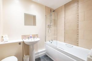 een badkamer met een wastafel, een toilet en een bad bij Apartment 10 in Worksop