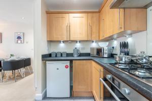 a kitchen with wooden cabinets and a white refrigerator at Apartment 10 in Worksop