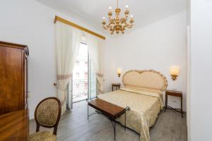 a bedroom with a bed and a table and a chandelier at Relais San Giacomo in Maiori