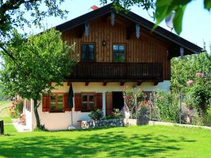 ein Holzhaus mit einem Balkon und einem Hof in der Unterkunft Beim Grafen in Frasdorf