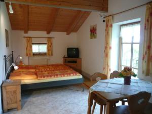 een slaapkamer met een groot bed en een tafel bij Beim Grafen in Frasdorf