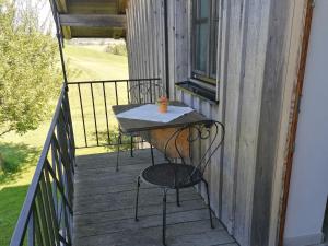 une table et deux chaises sur une terrasse en bois dans l'établissement Beim Grafen, à Frasdorf