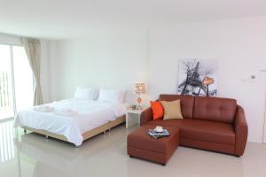 a bedroom with a bed and a couch at The Terrace Hotel in Nakhon Si Thammarat