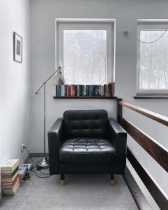 Prądnik KorzkiewskiにあるPradnik Valley Lodgeの窓付きの客室で、黒い革張りの椅子が備わります。