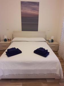 2 handdoeken op een wit bed in een kamer bij Sea Lovers Italy Apartment in Porto Recanati