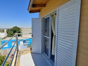 a balcony with a sliding glass door on a house at Ruca Kiñe Hostel in Las Grutas