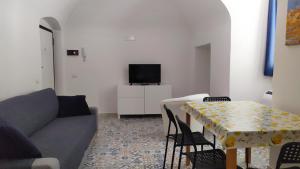 een woonkamer met een bank en een tafel met stoelen bij Dimora storica a Canosa di Puglia in Canosa di Puglia