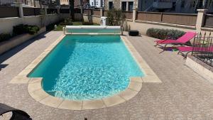 a swimming pool with a bench next to a building at Belle maison de famille in Usson-en-Forez