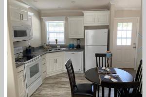 une cuisine avec une table et un réfrigérateur blanc dans l'établissement Resort Cottage near parks at Great Price!, à Kissimmee 6 autres photos