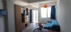 uma sala de estar com um sofá azul e uma mesa em Splash Apartments em Makry Gialos