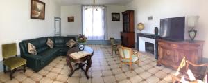 - un salon avec un canapé vert et une cheminée dans l'établissement COTTAGE SAINTE GENEVIEVE, à Champigny-sur-Veude