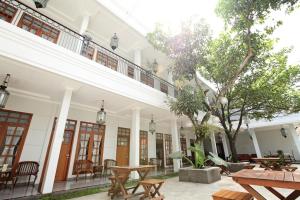 a courtyard of a building with tables and chairs at de' Halimun Guest House in Bandung